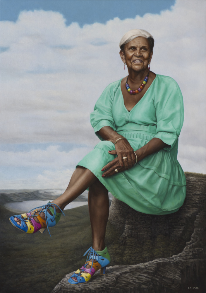 Portrait of Pamela Pedersen sitting on a vast landscape.